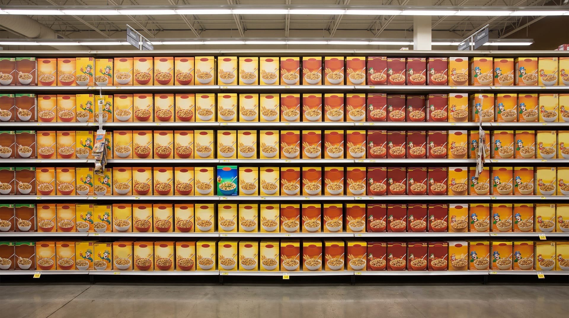 Raft de supermarket cu numeroase produse similare și un produs evidențiat prin contrast vizual