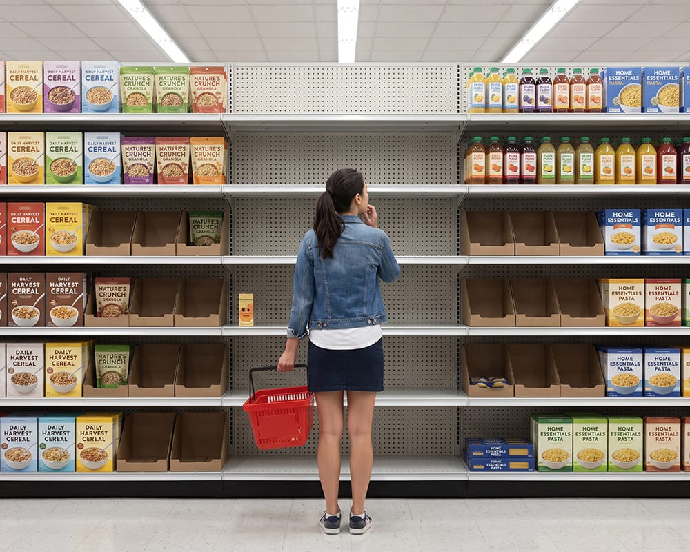 Retail Execution – disponibilitatea produselor la raft Shopper în fața unui raft de supermarket cu numeroase spații goale și produse indisponibile